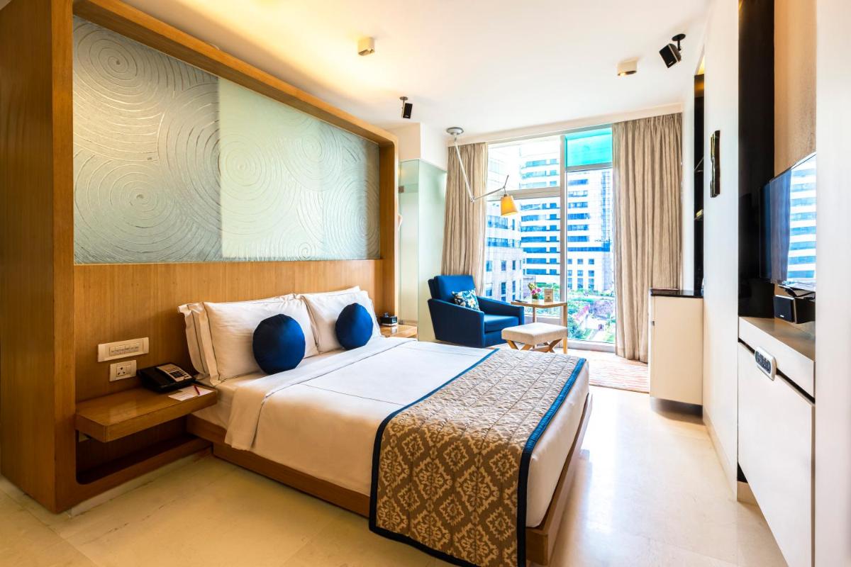 a hotel room with a bed and a television at Vivanta Bengaluru, Whitefield in Bengaluru