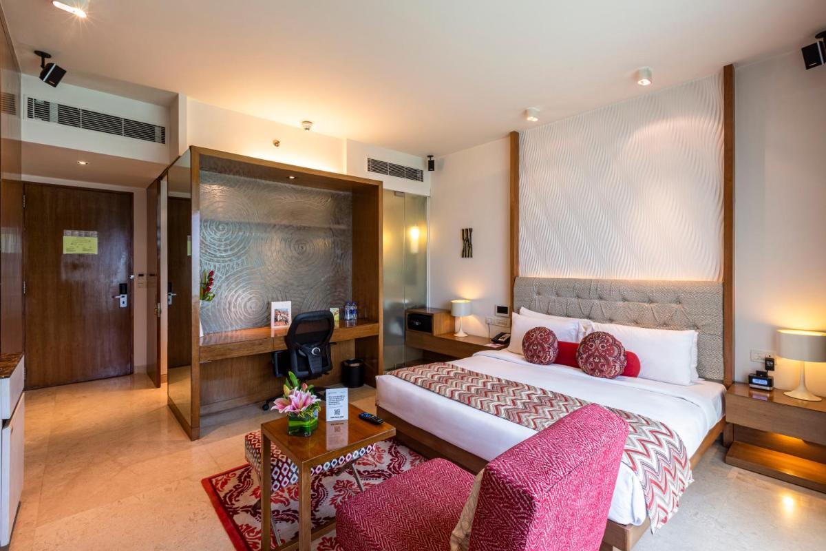 a hotel room with a bed and a couch at Vivanta Bengaluru, Whitefield in Bengaluru