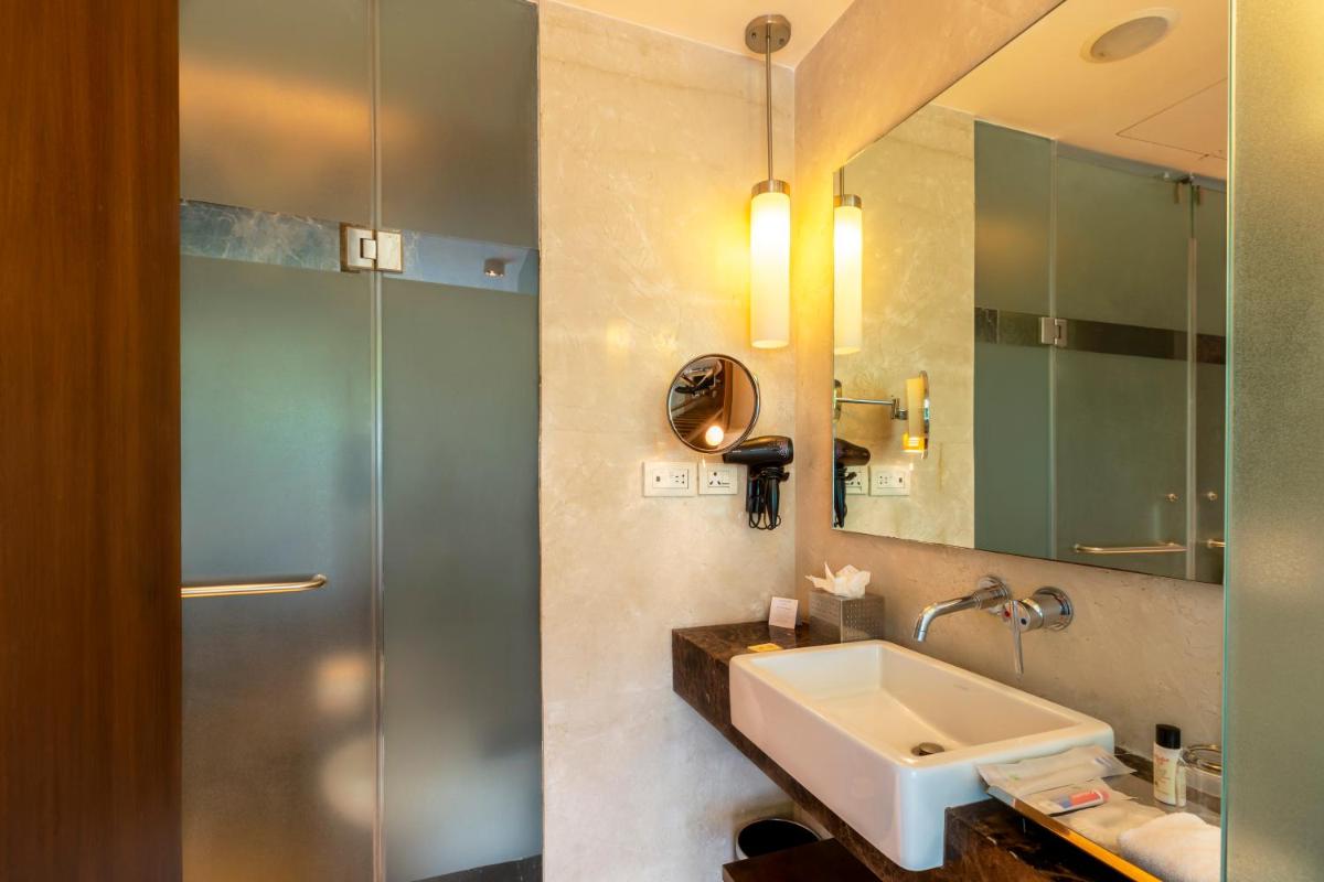 a bathroom with a sink and a mirror at Vivanta Bengaluru, Whitefield in Bengaluru