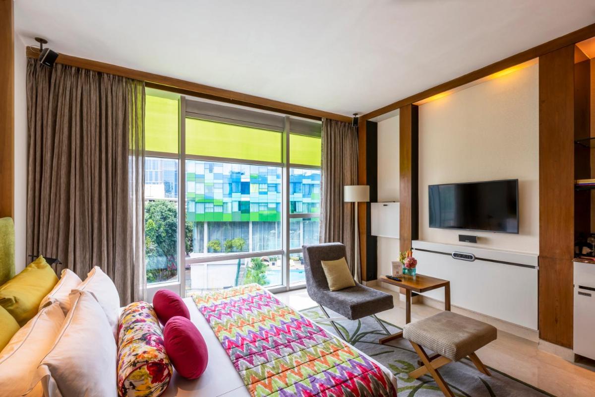 a living room with a couch and a large window at Vivanta Bengaluru, Whitefield in Bengaluru