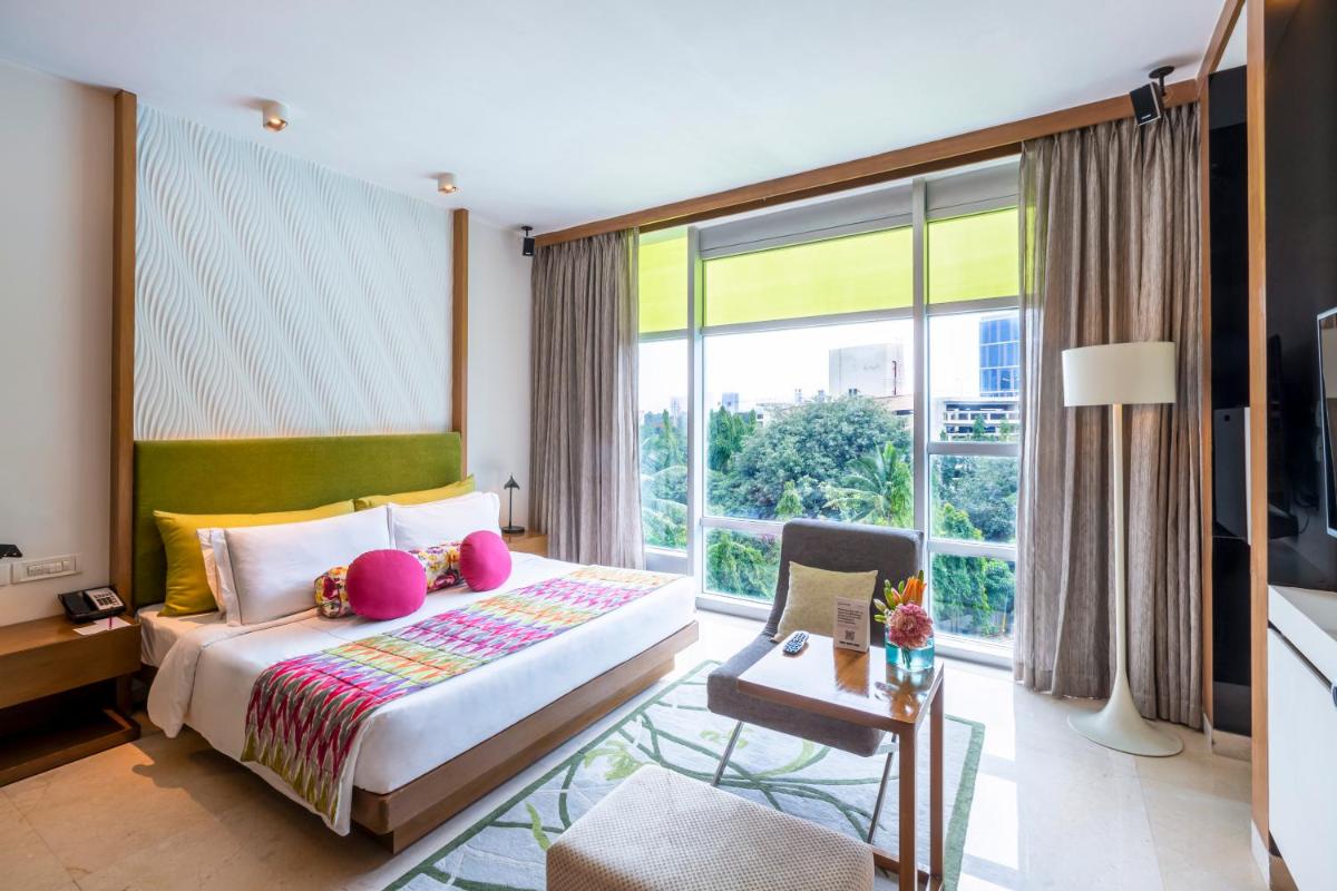 a bedroom with a bed and a large window at Vivanta Bengaluru, Whitefield in Bengaluru