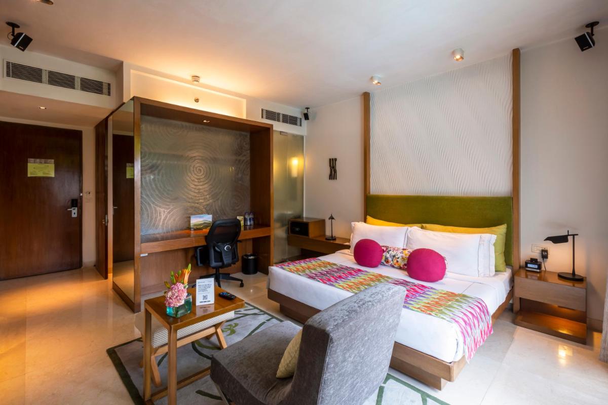 a hotel room with a bed and a desk at Vivanta Bengaluru, Whitefield in Bengaluru