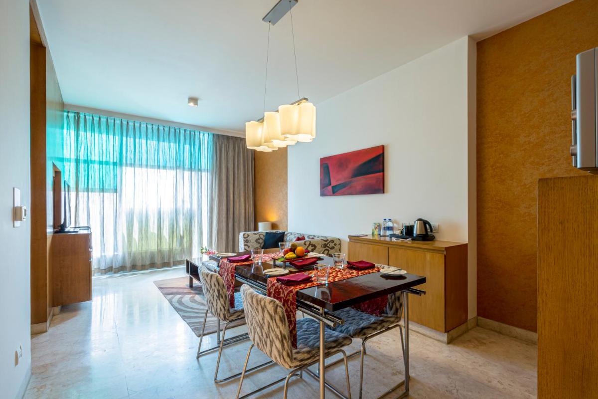 a living room with a dining room table and chairs at Vivanta Bengaluru, Whitefield in Bengaluru