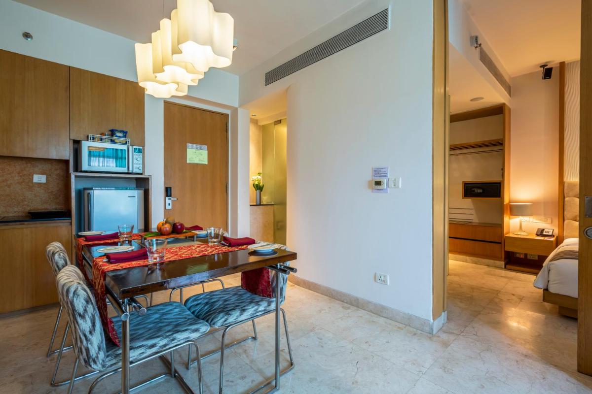 a kitchen with a table and chairs in a room at Vivanta Bengaluru, Whitefield in Bengaluru