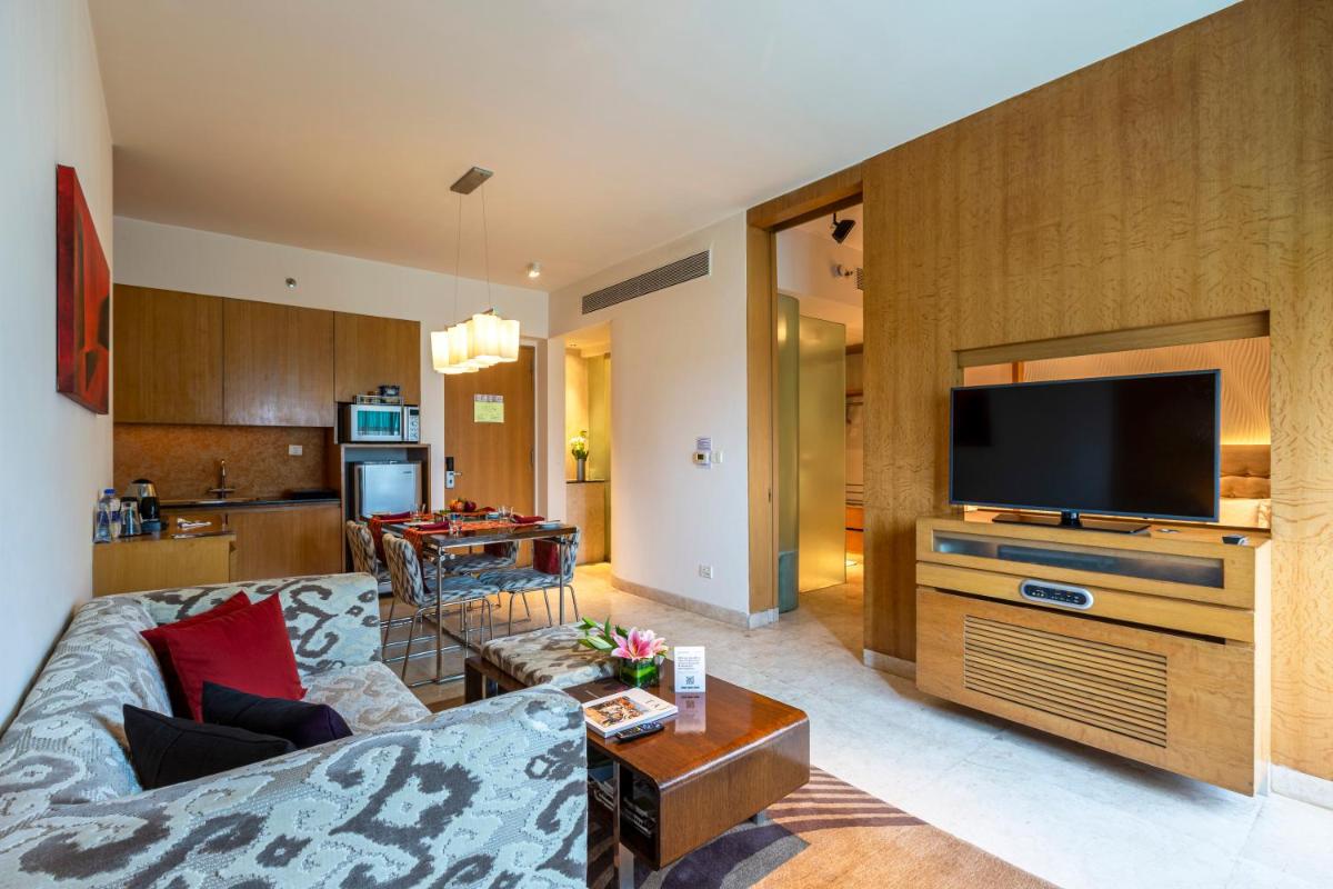 a living room with a couch and a flat screen tv at Vivanta Bengaluru, Whitefield in Bengaluru