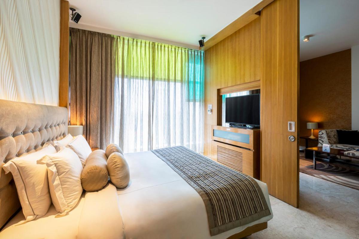 a bedroom with a large bed and a television at Vivanta Bengaluru, Whitefield in Bengaluru