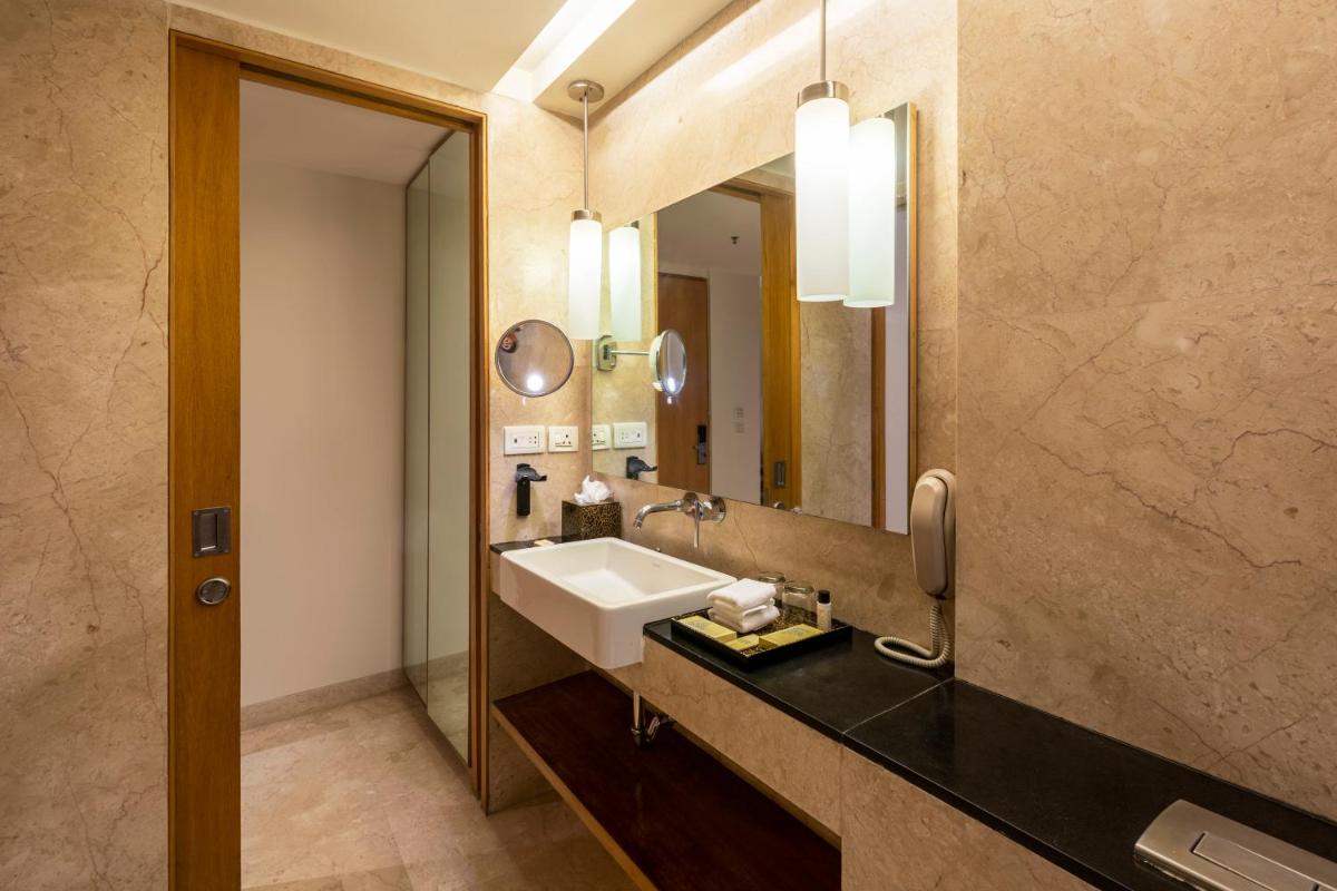 a bathroom with a sink and a mirror at Vivanta Bengaluru, Whitefield in Bengaluru
