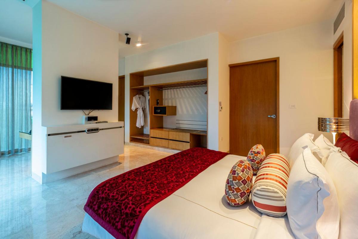 a bedroom with a large bed and a flat screen tv at Vivanta Bengaluru, Whitefield in Bengaluru