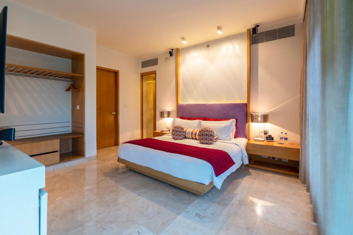a bedroom with a large bed and a television at Vivanta Bengaluru, Whitefield in Bengaluru