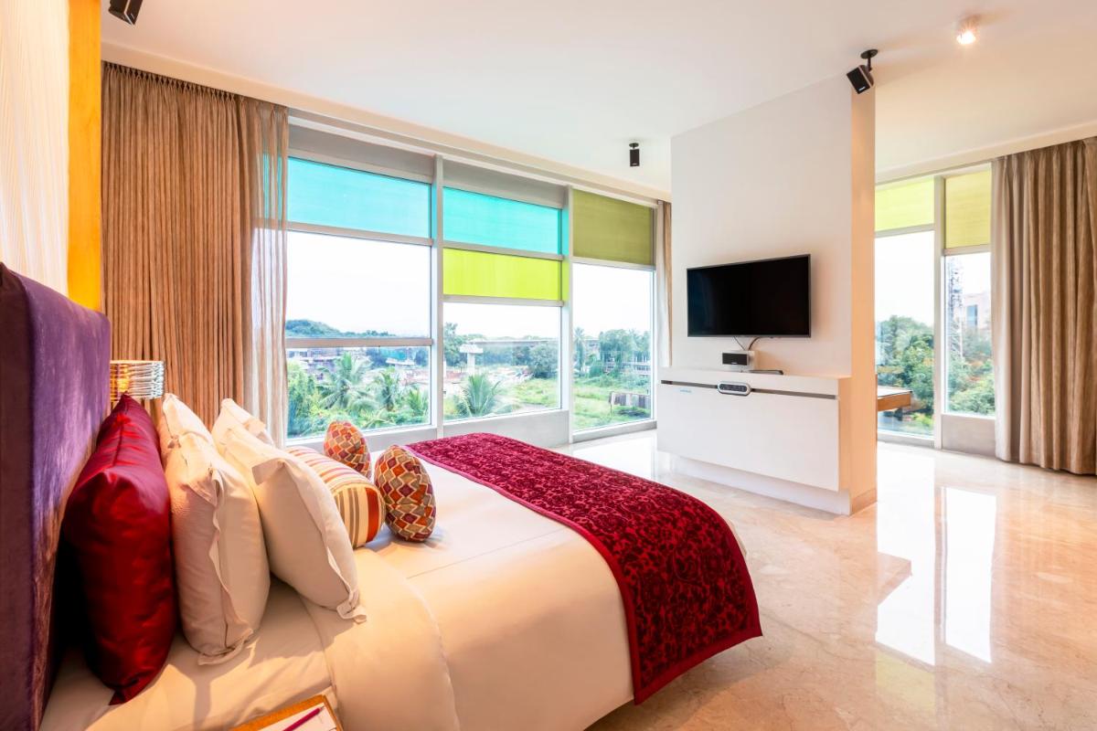 a bedroom with a large bed with a large window at Vivanta Bengaluru, Whitefield in Bengaluru