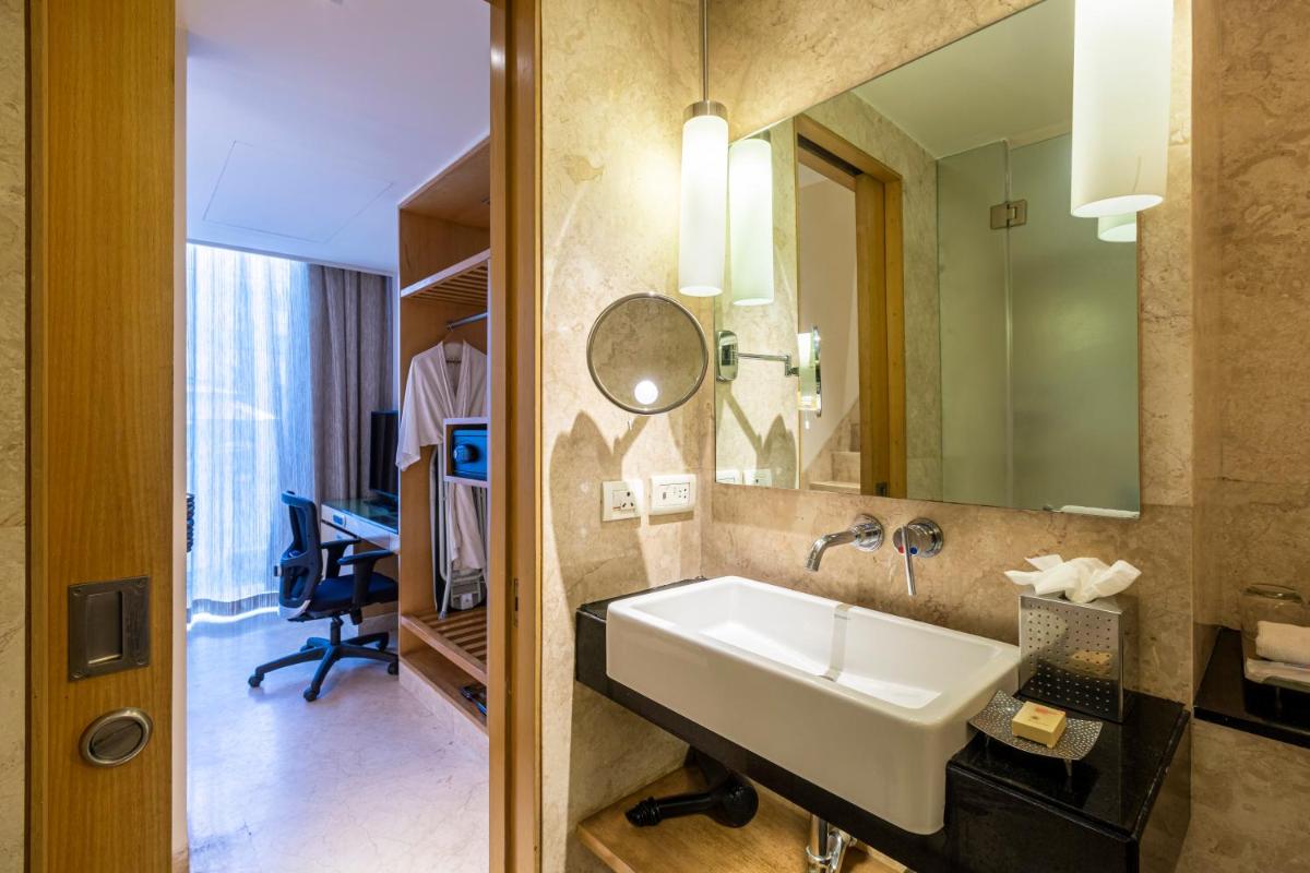 a bathroom with a sink and a mirror at Vivanta Bengaluru, Whitefield in Bengaluru