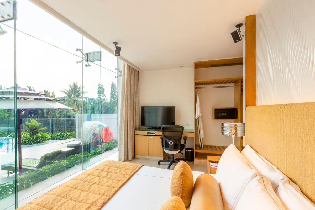 a hotel room with a bed and a large window at Vivanta Bengaluru, Whitefield in Bengaluru