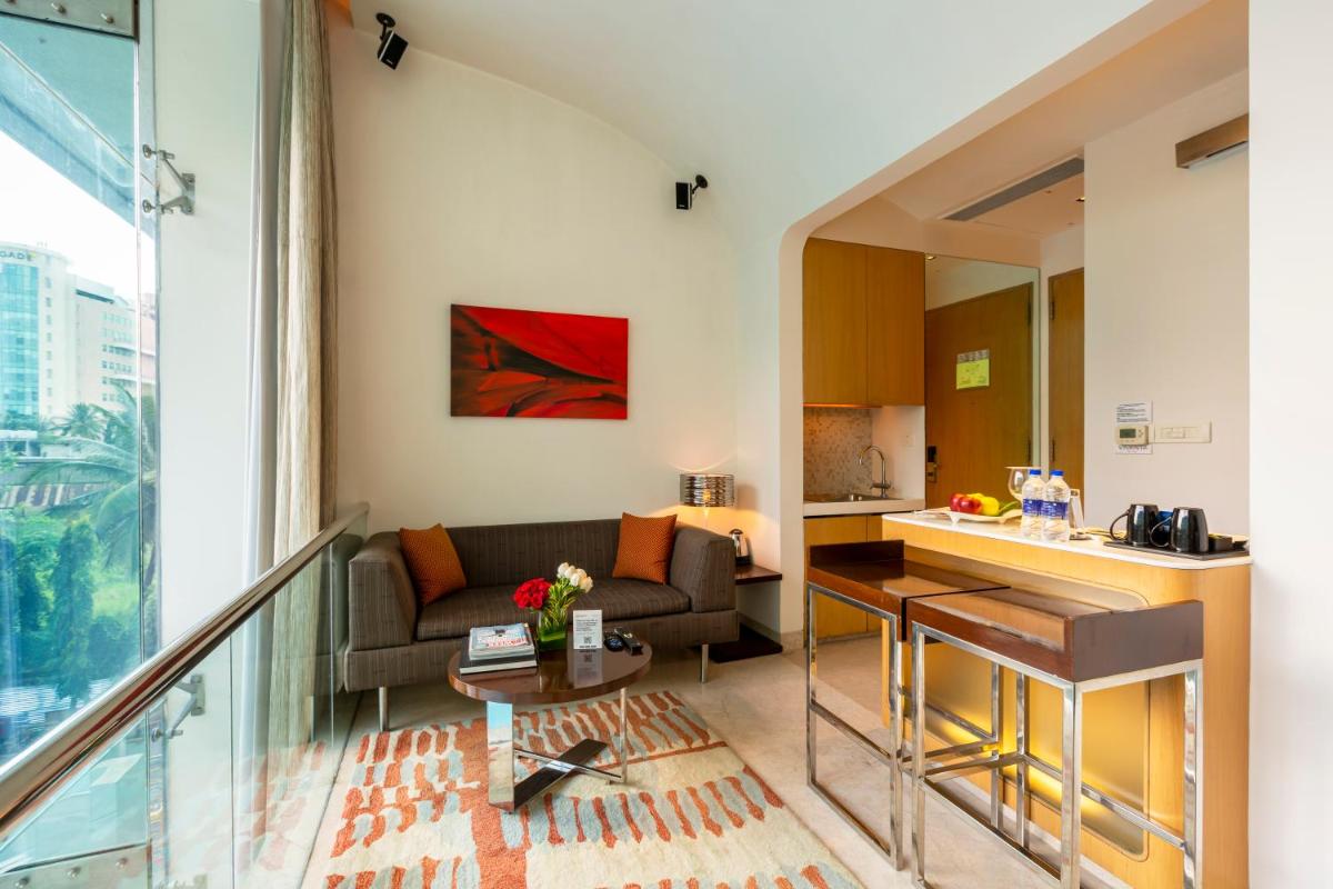 a living room with a couch and a table at Vivanta Bengaluru, Whitefield in Bengaluru