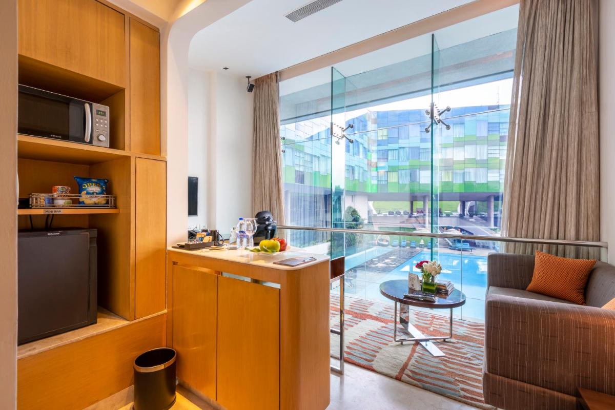 a living room with a large window and a table at Vivanta Bengaluru, Whitefield in Bengaluru