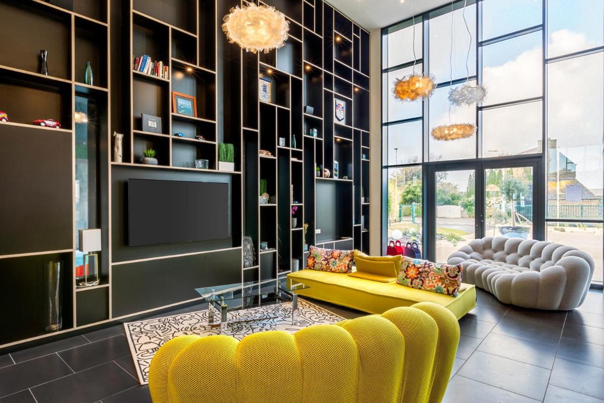 un salon avec un canapé jaune et une télévision dans l'établissement Best Western Plus Europe Hôtel Brest, à Brest