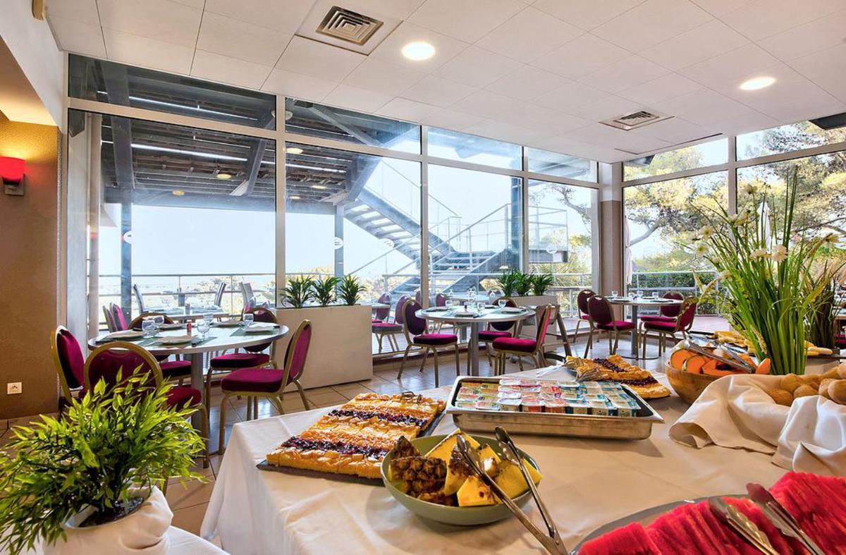une cafétéria avec un buffet de plats sur une table dans l'établissement Hôtel Club la Font des Horts, à Hyères