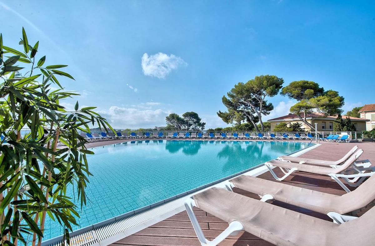 une piscine avec deux chaises longues à côté dans l'établissement Hôtel Club la Font des Horts, à Hyères