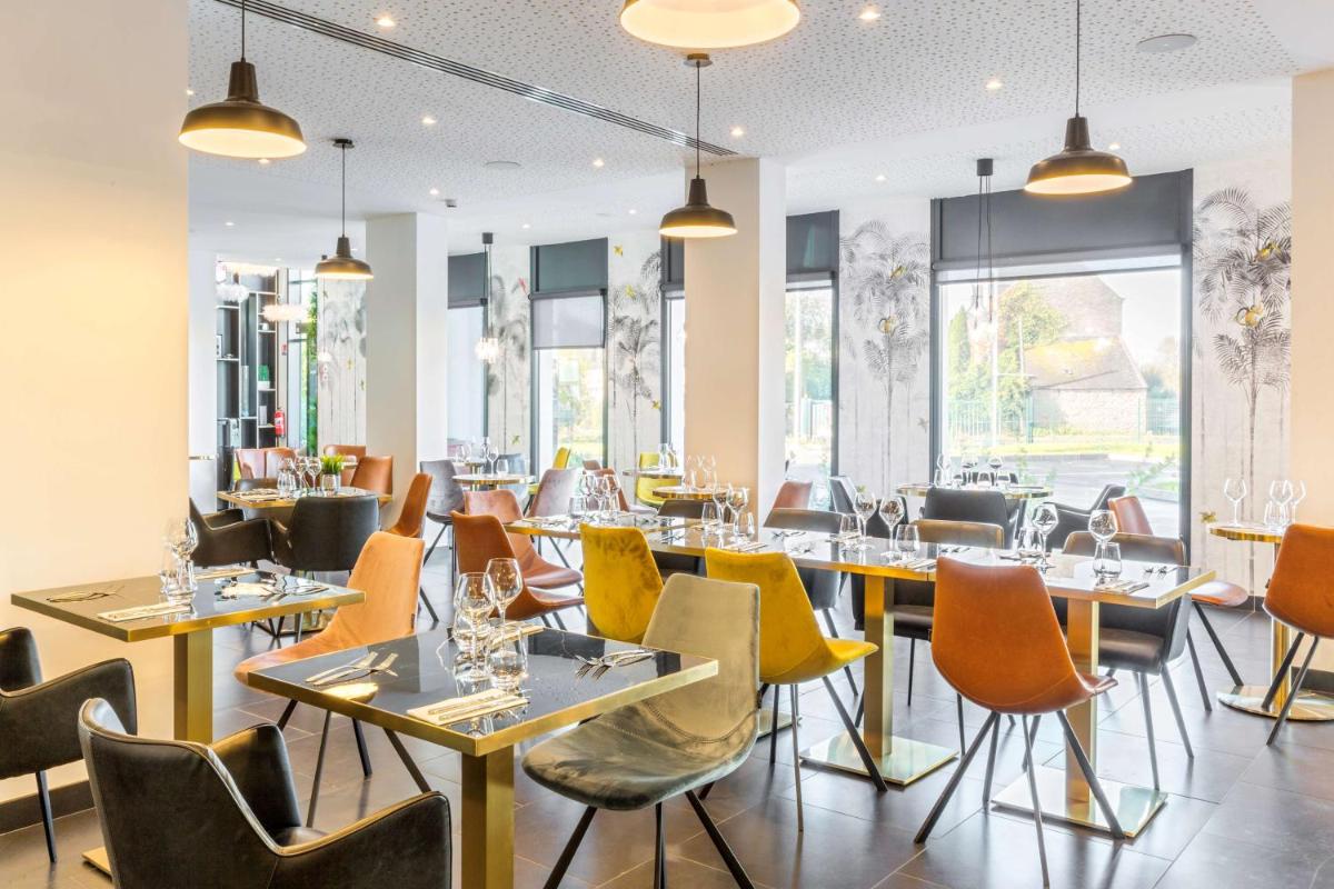 un restaurant avec des tables, des chaises et des fenêtres dans l'établissement Best Western Plus Europe Hôtel Brest, à Brest