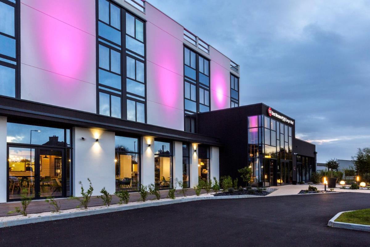un bâtiment avec des lumières roses sur le côté dans l'établissement Best Western Plus Europe Hôtel Brest, à Brest