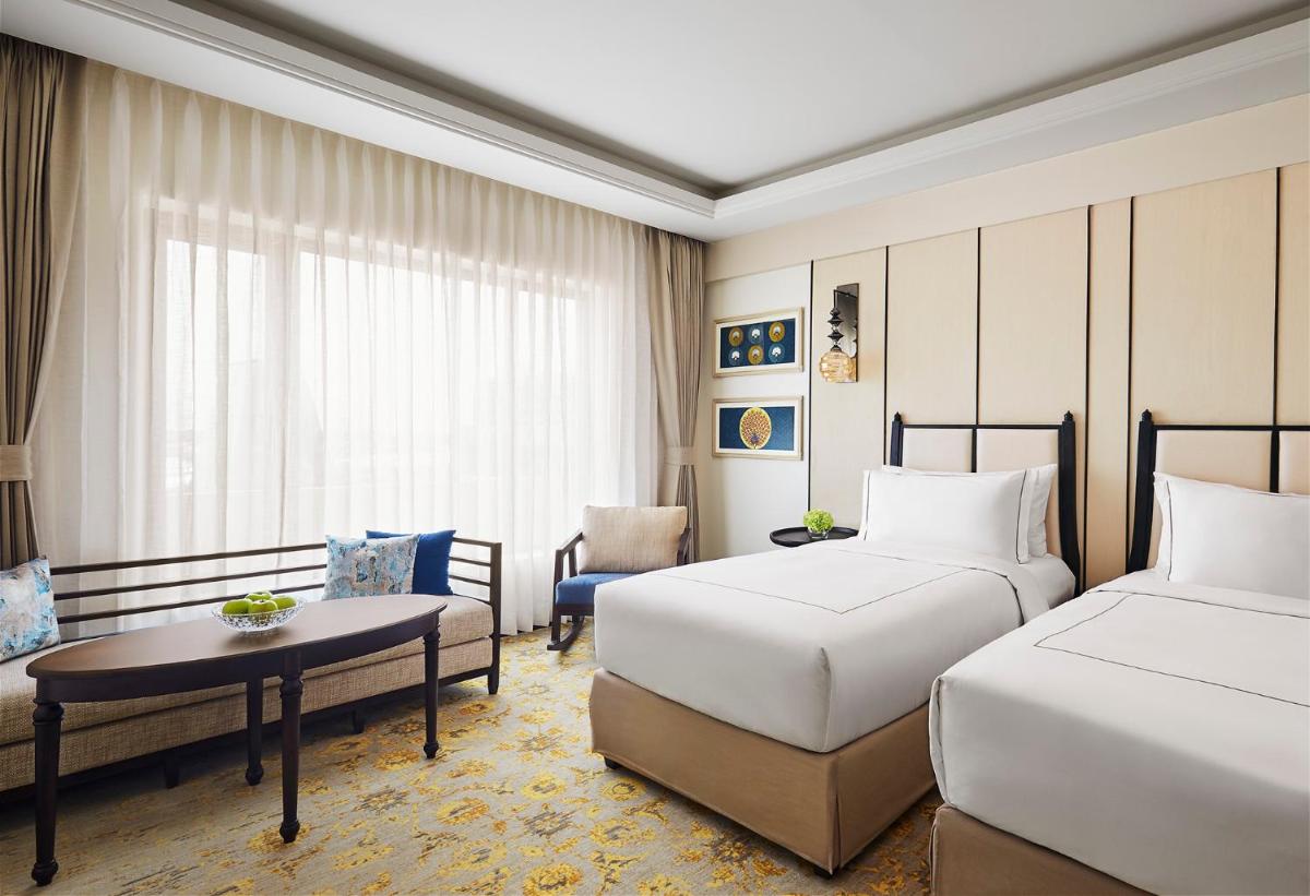 a hotel room with two beds and a table at Taj Tirupati in Tirupati