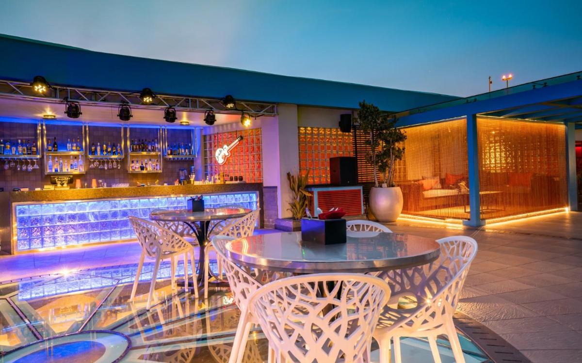 a patio with tables and chairs and a bar at Hyatt Place Hyderabad Banjara Hills in Hyderabad