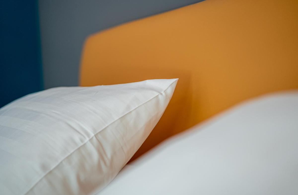 Un ou plusieurs lits dans un hébergement de l'établissement PoMo Hôtel & Restaurant