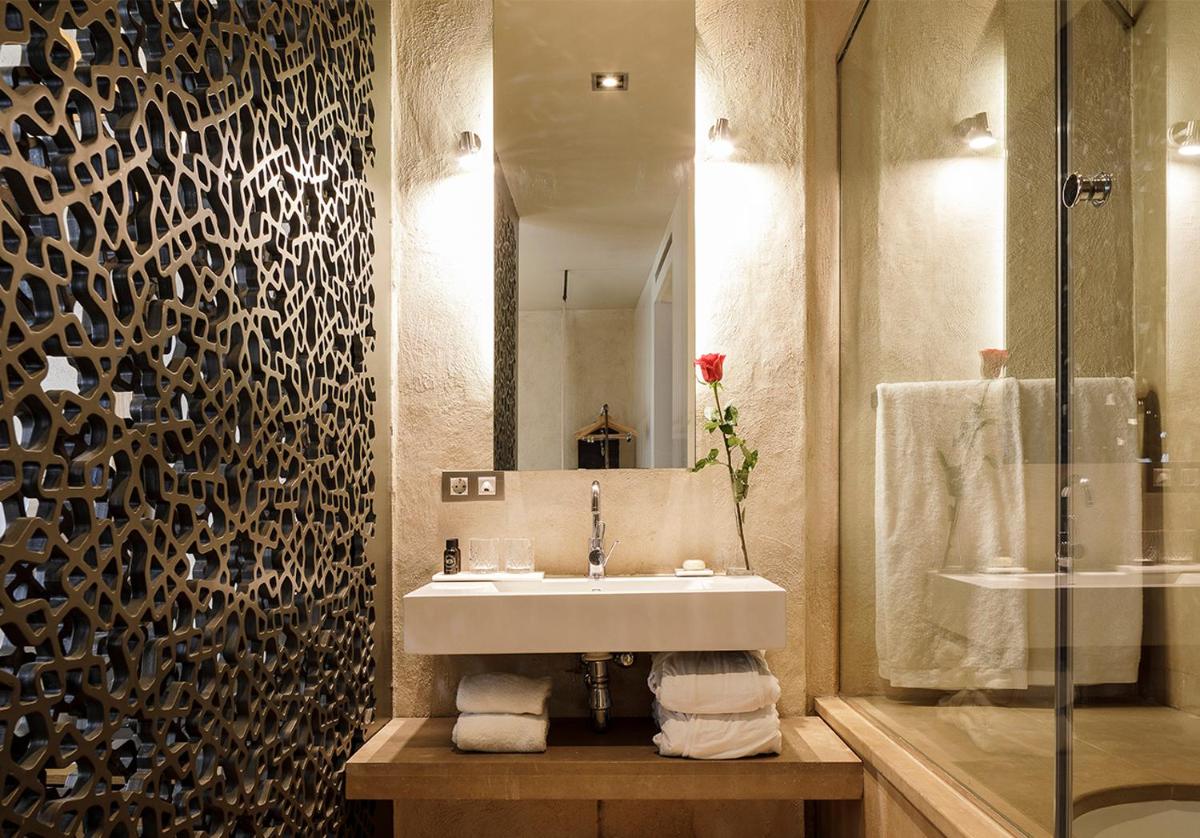 un baño con lavabo y espejo en EME Catedral Mercer Hotel, en Sevilla