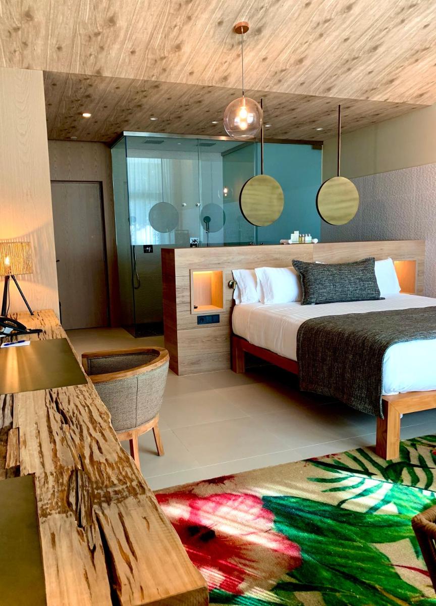 Un dormitorio con una cama, una mesa y un sofá. en Playa Grande by Tropical - Adults Only, en Gavà