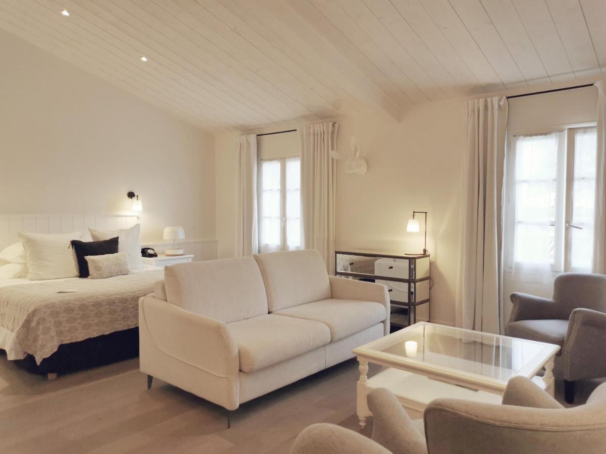 - un salon avec un lit et un canapé blanc dans l'établissement Le Clos Saint-Martin Hôtel & Spa, à Saint-Martin-de-Ré
