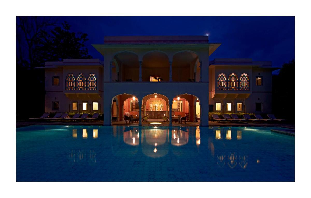 a large building with a swimming pool at night at Samode Haveli in Jaipur