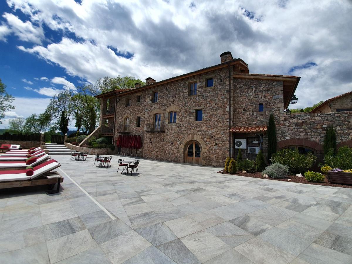 un gran edificio de ladrillo con sillas y un patio en Hotel Boutique Puig Francó - Adults Only, en Camprodon