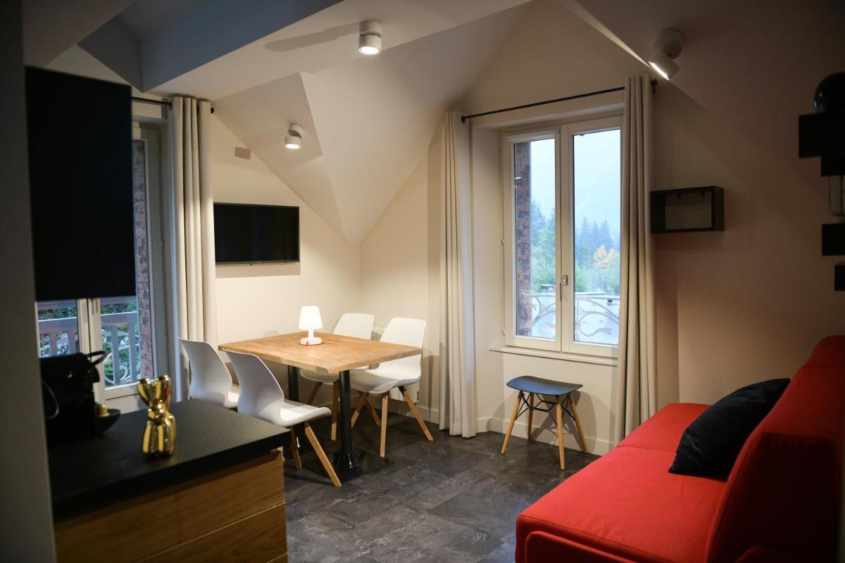 un salon avec un canapé rouge et une table dans l'établissement Appart'Hotel Aiguille Verte & Spa, à Chamonix-Mont-Blanc