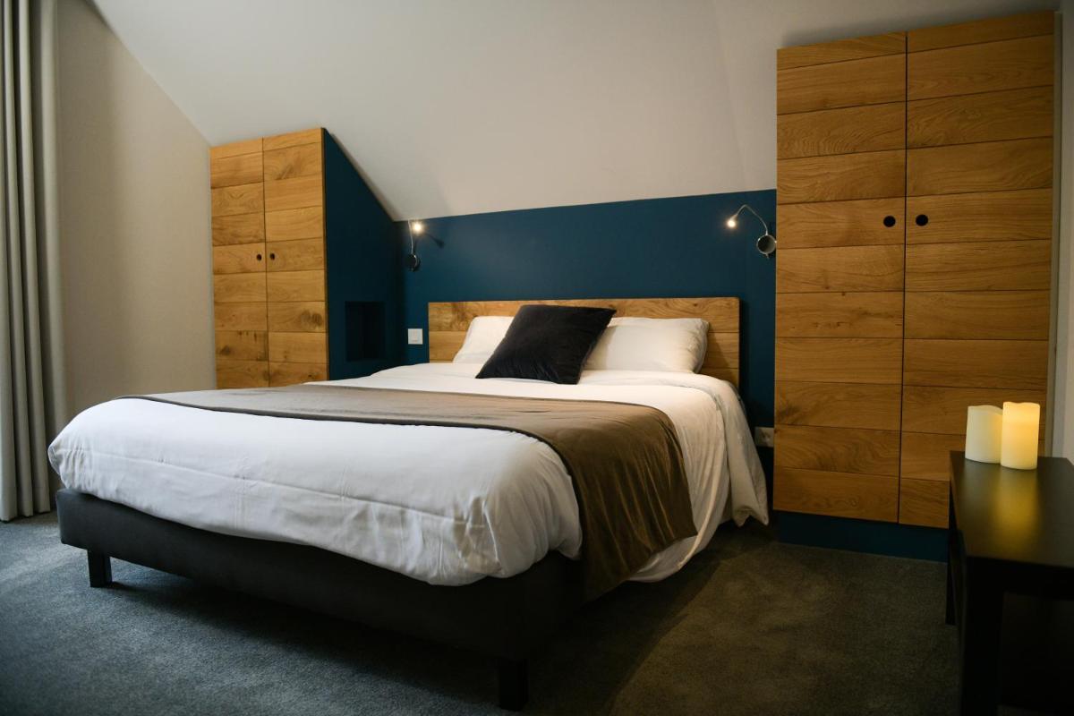 une chambre avec un grand lit avec un mur bleu dans l'établissement Appart'Hotel Aiguille Verte & Spa, à Chamonix-Mont-Blanc