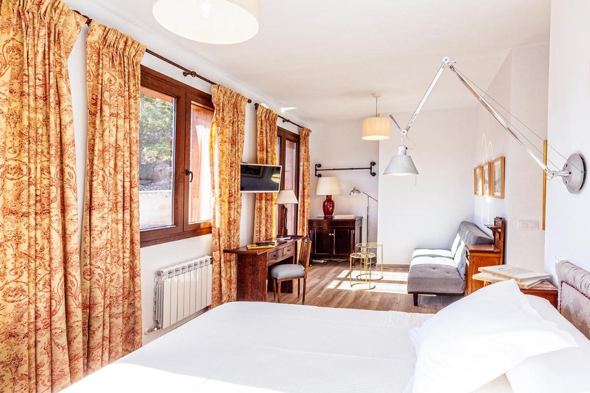 Un dormitorio con una cama y una sala de estar. en Hotel Spa Salinas de Imón, en Imón 63 fotos más