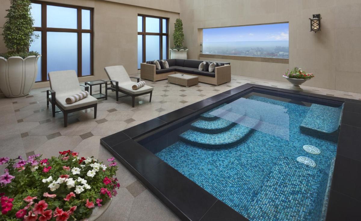 a living room with a large swimming pool at The Leela Palace New Delhi in New Delhi a living room with a large swimming pool at The Leela Palace New Delhi in New Delhi