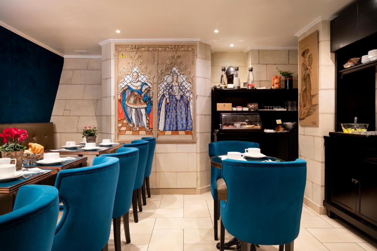 un restaurant avec des chaises bleues et un tableau au mur dans l'établissement Hotel Residence Henri IV, à Paris