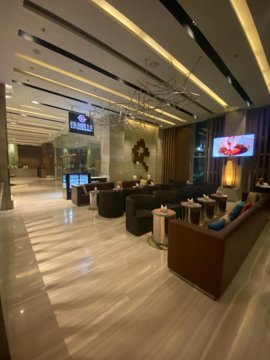 a lobby with couches and tables in a building at Welcomhotel by ITC Hotels, Richmond Road, Bengaluru in Bengaluru
