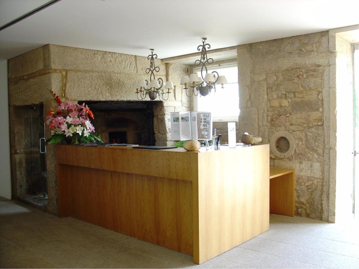 uma cozinha com um balcão de madeira e uma lareira em Hotel Convento dos Capuchos em Monção mais 56 fotografias