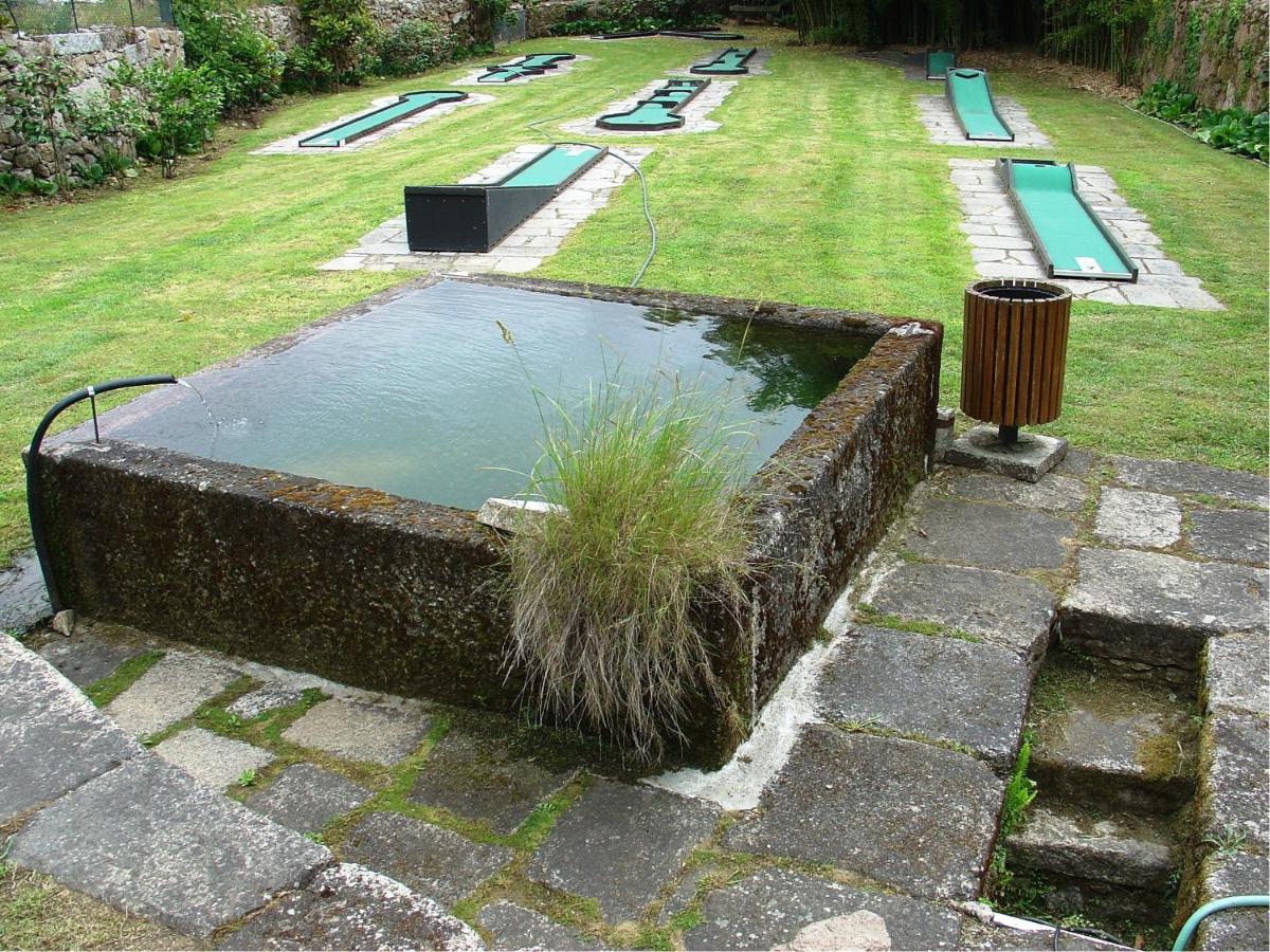 uma piscina de água num quintal com parque infantil em Hotel Convento dos Capuchos em Monção