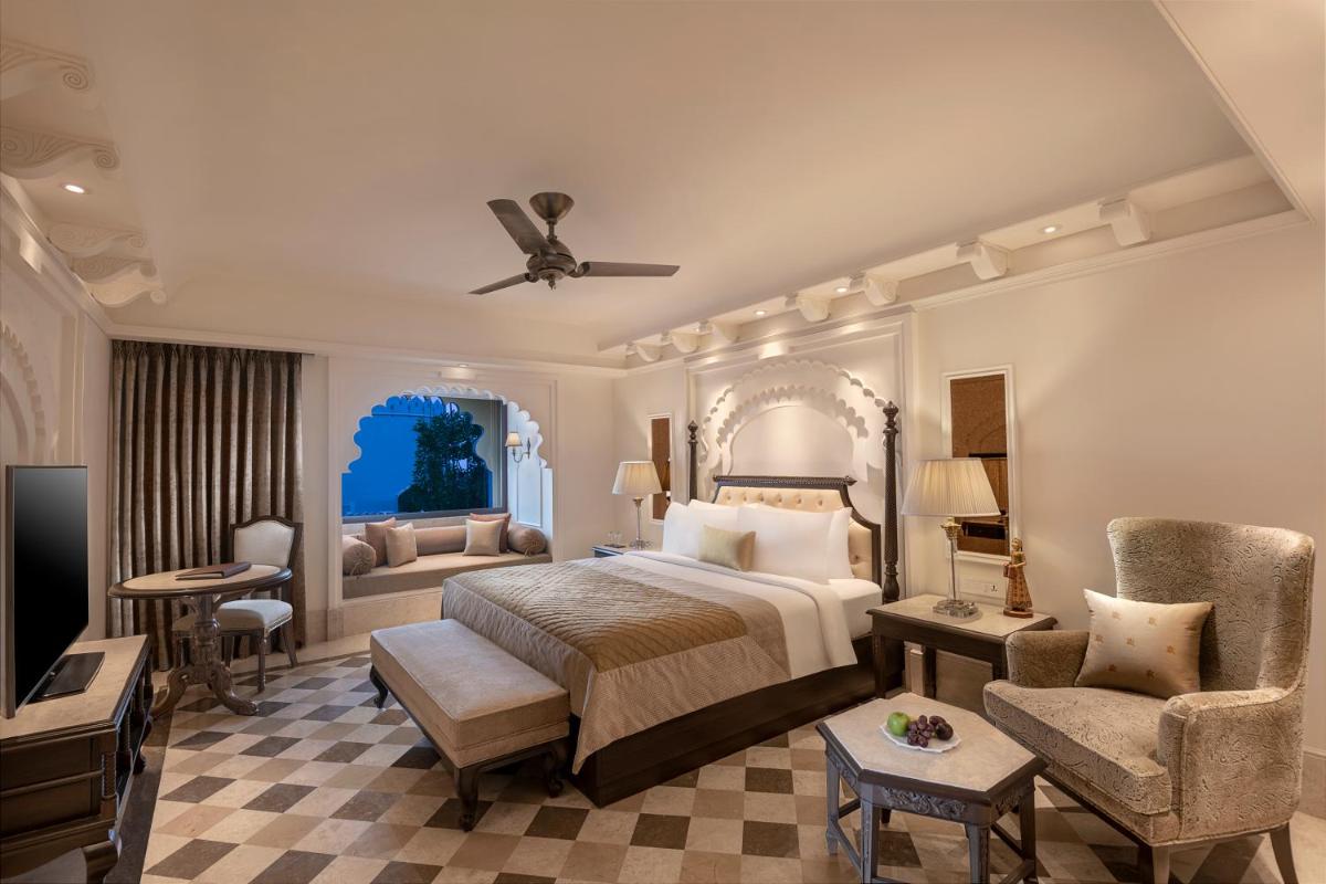 a bedroom with a bed and a couch and a television at Aurika, Udaipur - Luxury by Lemon Tree Hotels in Udaipur