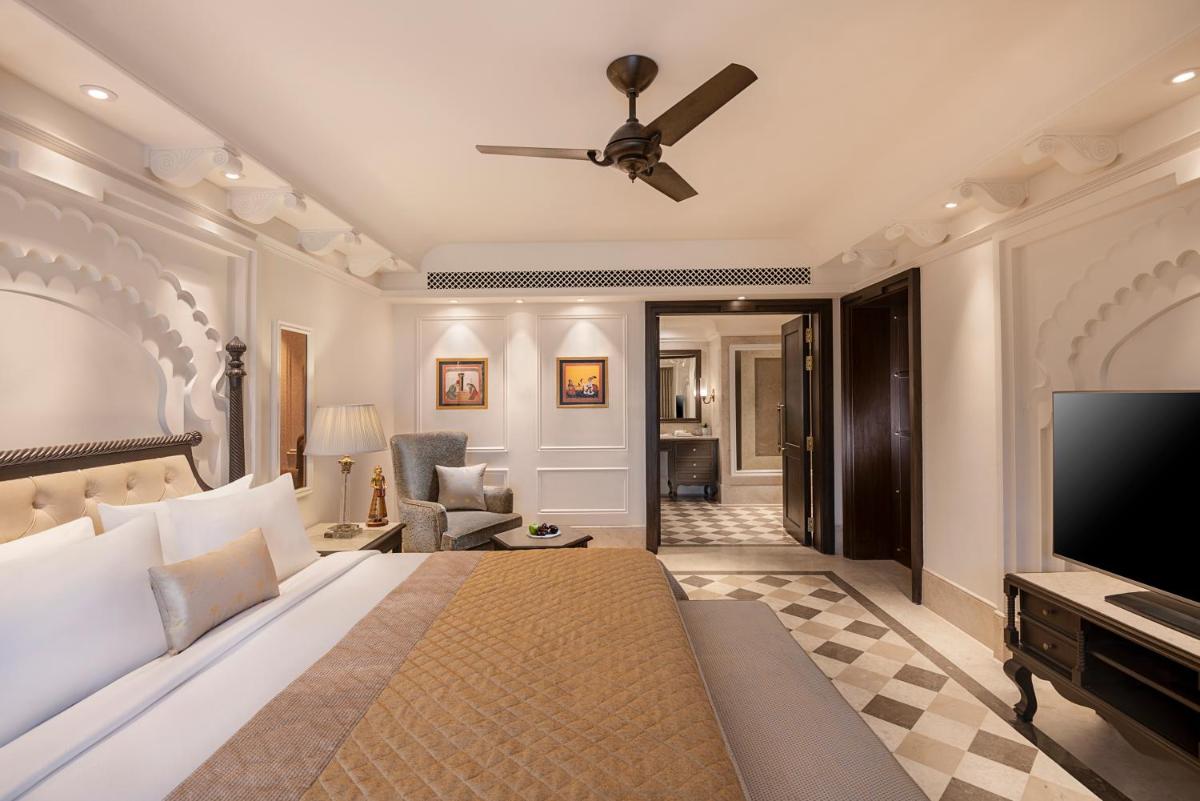 a bedroom with a bed and a ceiling fan at Aurika, Udaipur - Luxury by Lemon Tree Hotels in Udaipur