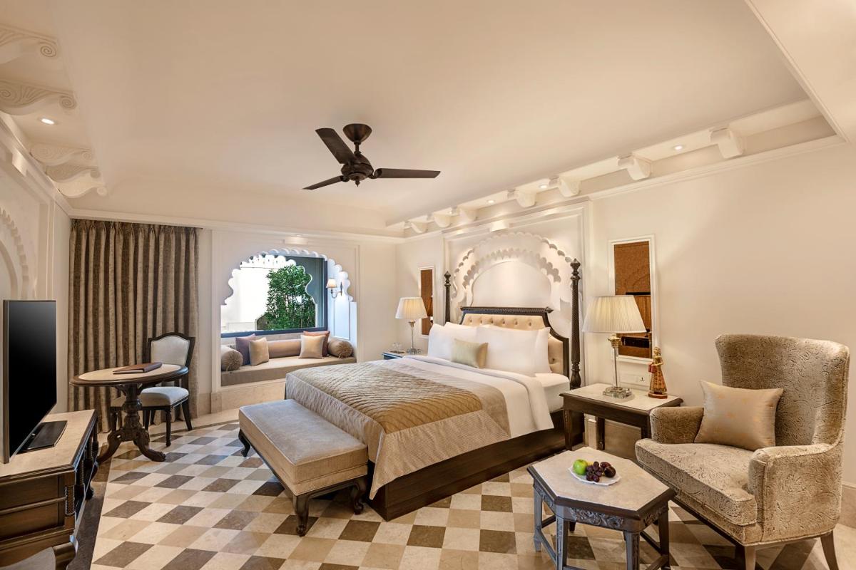 a bedroom with a bed and a living room at Aurika, Udaipur - Luxury by Lemon Tree Hotels in Udaipur