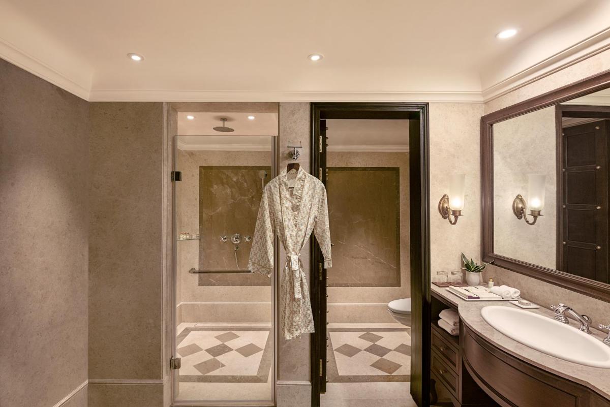 a bathroom with a robe hanging on the door of a shower at Aurika, Udaipur - Luxury by Lemon Tree Hotels in Udaipur