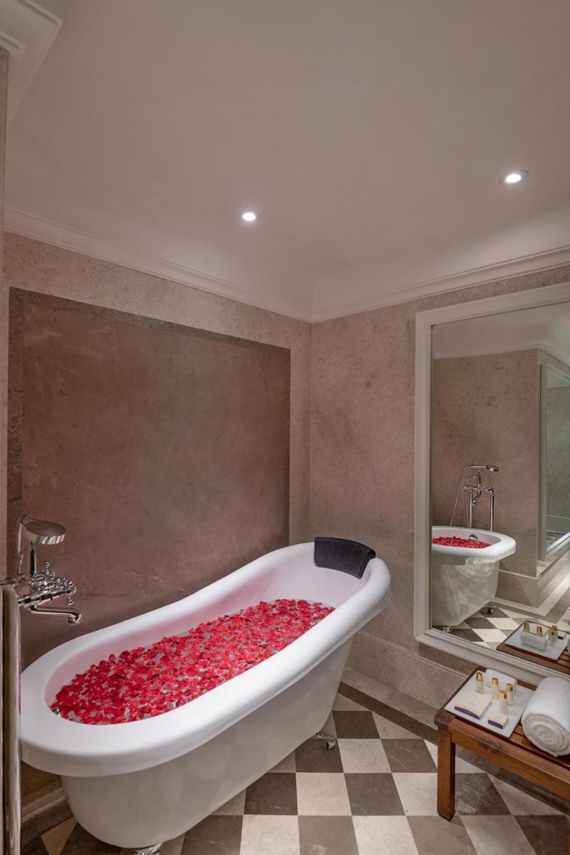a bathroom with a large tub filled with red roses at Aurika, Udaipur - Luxury by Lemon Tree Hotels in Udaipur