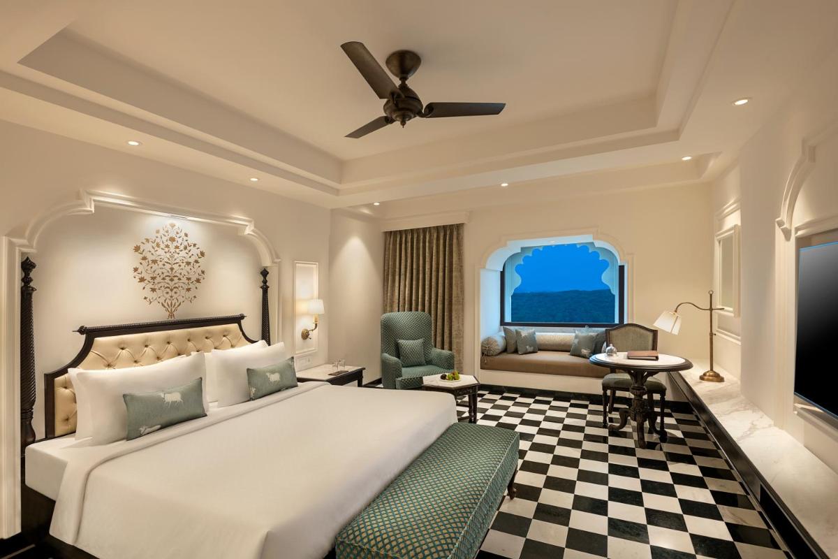a bedroom with a large bed and a desk at Aurika, Udaipur - Luxury by Lemon Tree Hotels in Udaipur