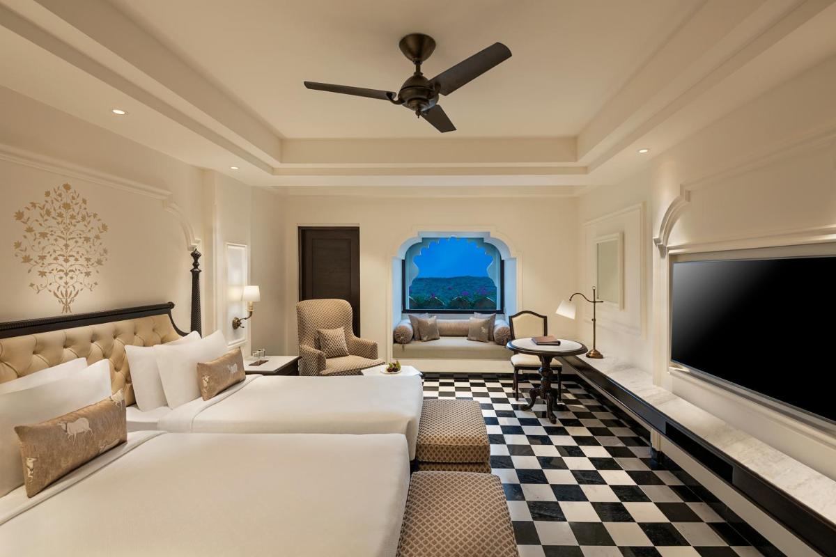 a hotel room with a bed and a flat screen tv at Aurika, Udaipur - Luxury by Lemon Tree Hotels in Udaipur