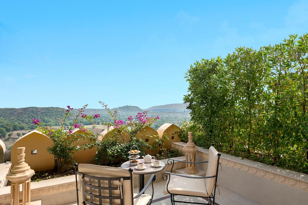 a patio with a table and chairs and flowers at Aurika, Udaipur - Luxury by Lemon Tree Hotels in Udaipur