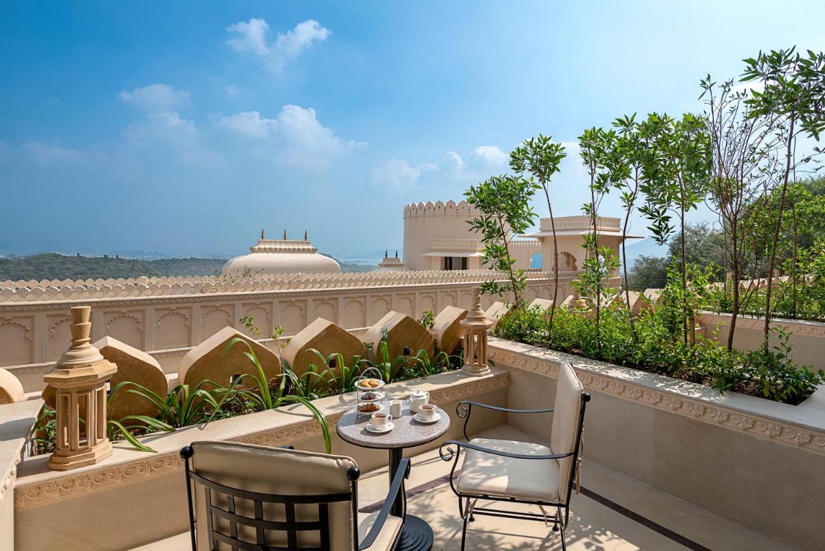 a patio with a table and chairs on a balcony at Aurika, Udaipur - Luxury by Lemon Tree Hotels in Udaipur