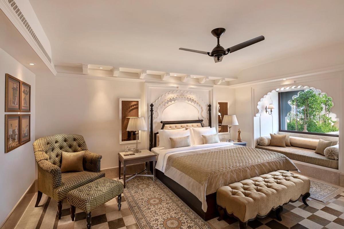 a bedroom with a bed and a couch and a window at Aurika, Udaipur - Luxury by Lemon Tree Hotels in Udaipur