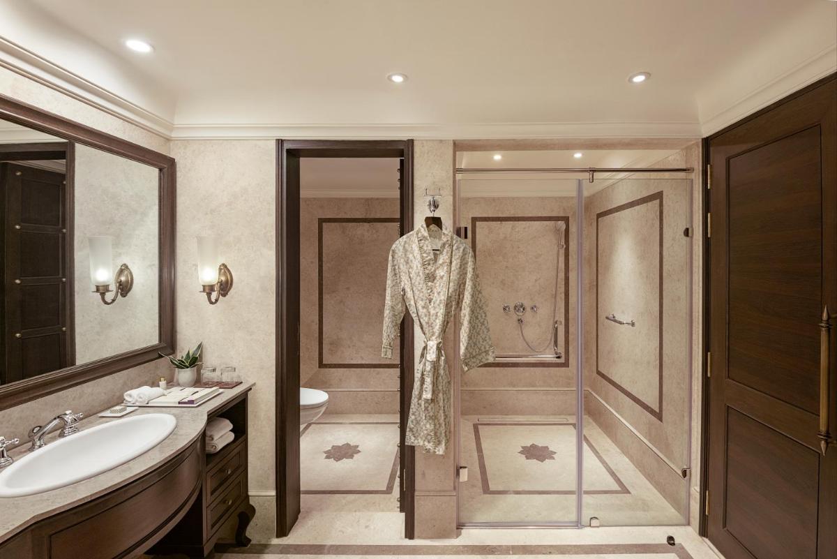 a bathroom with a robe hanging on the door at Aurika, Udaipur - Luxury by Lemon Tree Hotels in Udaipur
